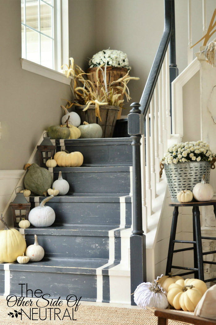 Such pretty fall decor: lined stairs with a mix of real and faux pumpkins. It helps to keep costs down and allows the decor to last throughout the seasons. Adore this fall decorated stairway! #falldecor #pumpkinlinedstairs #decoratingstairsforfall #fallstairwaydecor #fauxpumpkins