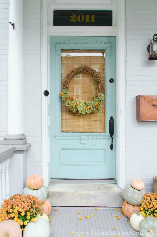 Loving this farmhouse fall porch full of mums and pumpkins. Lots of fun ways to decorate your porch stairs for fall! #falldecor #decoratingporchforfall #pumpkinsandmums #falldecorations