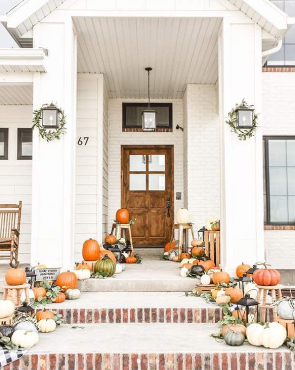 Looooving this farmhouse fall porch with pumpkins, so pretty! #farmhousefalldecor #frontporchdecor #decoratingwithpumpkins #pumpkinsstairsporch