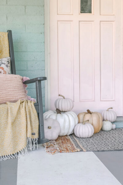 Eek! Love the pops of PINK in this cheery fall decor on this cozy porch! #fall #fallporch #falldecorations