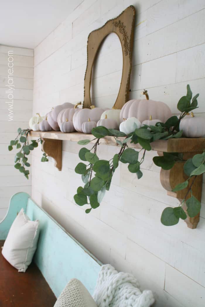 Have fun with color this fall! Add chalk paint pink pumpkins with gold stems with eucalyptus leaves tucked in create a simple fall mantel. Love these pink and white pumpkin fall colors! #fallmantel #falldecor #pinkwhitepumpkins #naturalfalldecor #blushpinkpumpkins #chalkpaintpumpkins