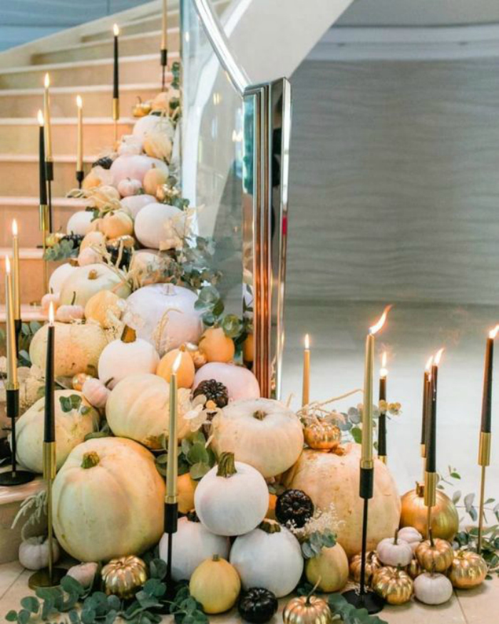 Such a gorgeous way to display fall decor!! Love these pumpkins candles eycalyptus leaves trailing down a stairway decorations. Stunning! #falldecor #fallstairwayideas #decoratingstairsforfall #howtodecoratestairsforfalldecor #falldecorations