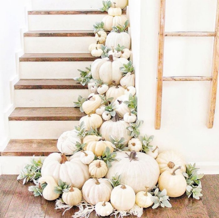 Lay white pumpkins with greenery for easy decorating on stairs. Love this pretty fall decor! #whitepumpkinsgreenery #decoratingstairsforfall #fallstairsdecorating #falldecoratingideas