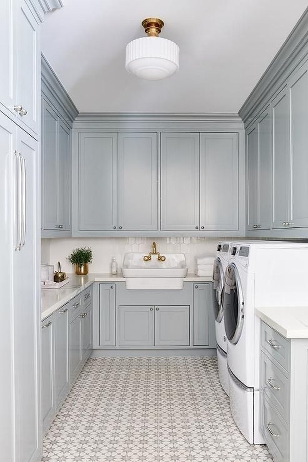 Adore this blue laundry room with patterned tile! Cutest gold and white flush mount light in this remodeled laundry room! #bluelaundryroom #renovatedlaundryroom #patternedtilefloors #trendyfloors