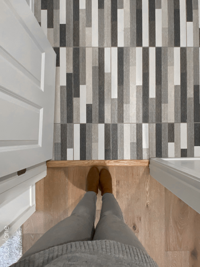 Gorgeous tile in this new build home, wow! It looks like carpet, such detailed texture! Read on to see the comparisons between buying new and resale! #modernfarmhouse #moderntile #bathroomtile #newbuild #kbhome