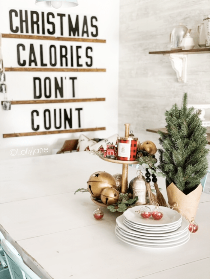 Learn how to put together this easy Christmas tiered tray using a pretty buffalo check tray and filled in with pretty neutral accents and a little eucalyptus greenery. #christmastieredtray #diytieredtray #christmastieredtraydiy #diychristmasdecor