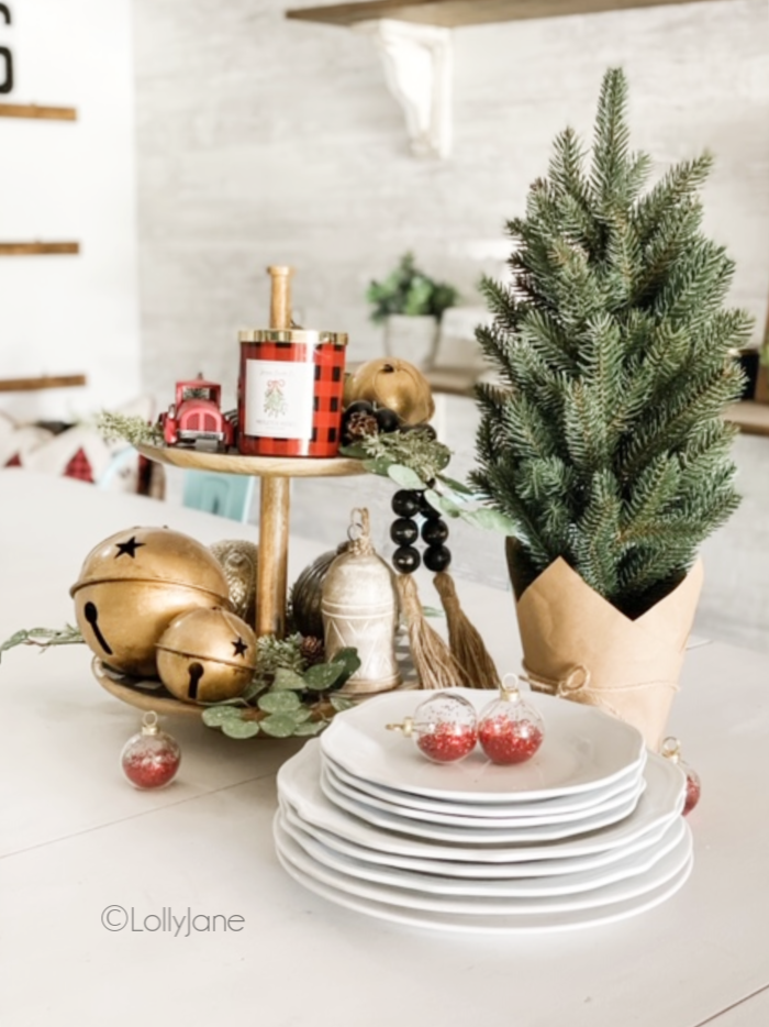 Such a pretty festive diy tiered tray using ornaments and greenery to create cheery all season long. #diytieredtray #christmastieredtray #christmascenterpiece #christmastablescape