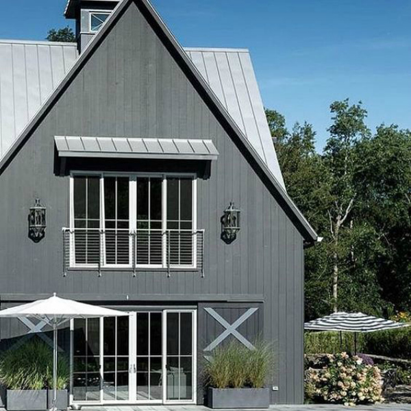 This pretty dark gray painted exterior was shared via SuCasaDesign and gives me all the feels! It's dark and moody but still feels cozy with the chic farmhouse metal roof and crossbuck shutters. #darkexteriorhouse #paintedexteriorhouses #darkexterior #grayhouseideas #farmhouseexterior