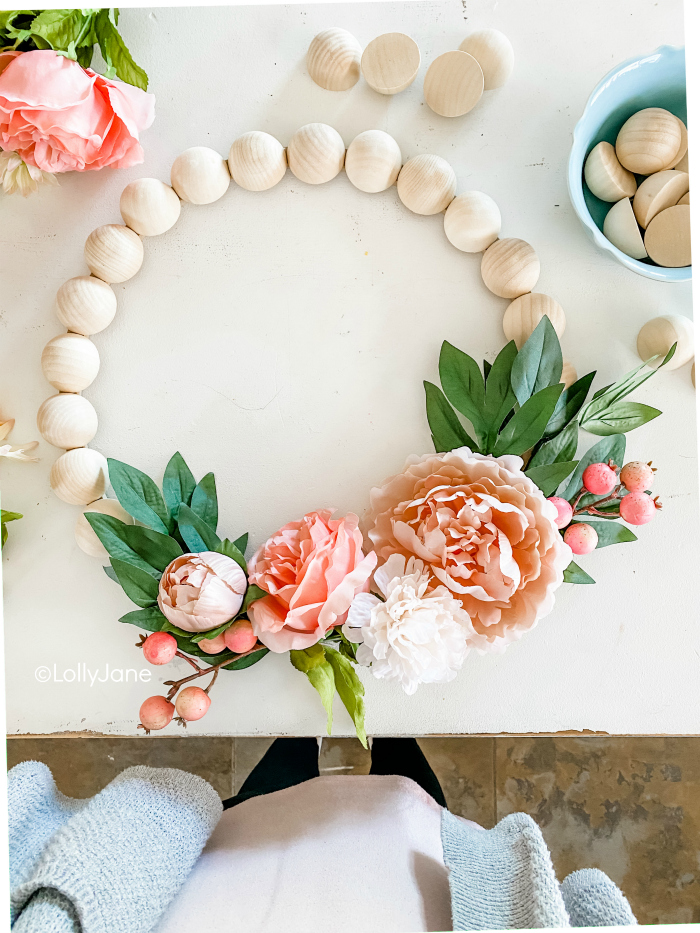 Learn how to make this easy wooden bead wreath with florals. Such a fun front door wreath with natural wood beads and pretty florals and berries. #woodbeadwreath #floralwreath #howtomakeawreath #easywreathtutorial #splitwoodbeadwreath