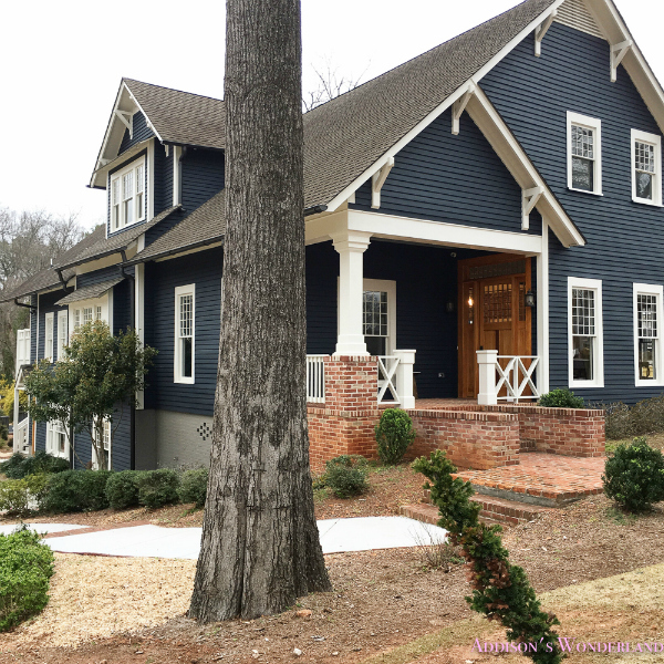 Such a gorgeous navy blue craftsman exterior paint color! Check out the inside house tour of this stunning recently remodeled historic home! #historichome #navyexteriorpaint #navypaintcolor #craftsmanhomepaintcolor #navyexteriorpaintcolors