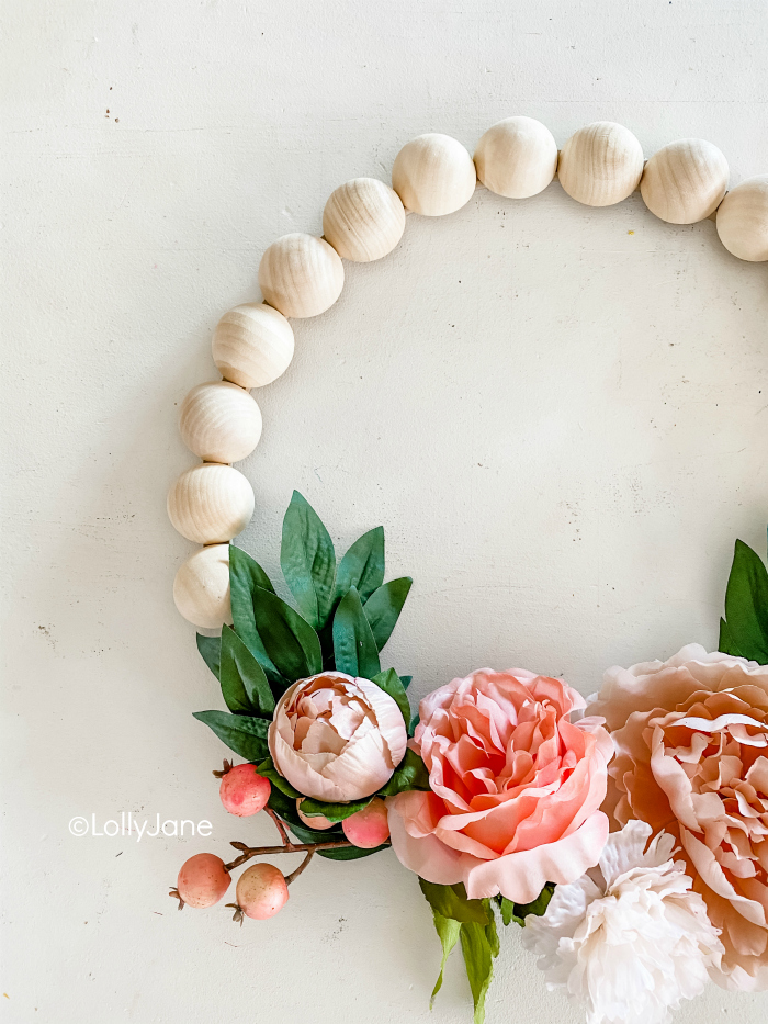 DIY pretty floral wreath with berries and wood beads. So easy to make this flower wreath with wooden beads and cute berry stems! #woodenbeadwreath #woodbeadwreath #splitwoodbeadwreath #flowerwreath #floralwreath #howto #diy