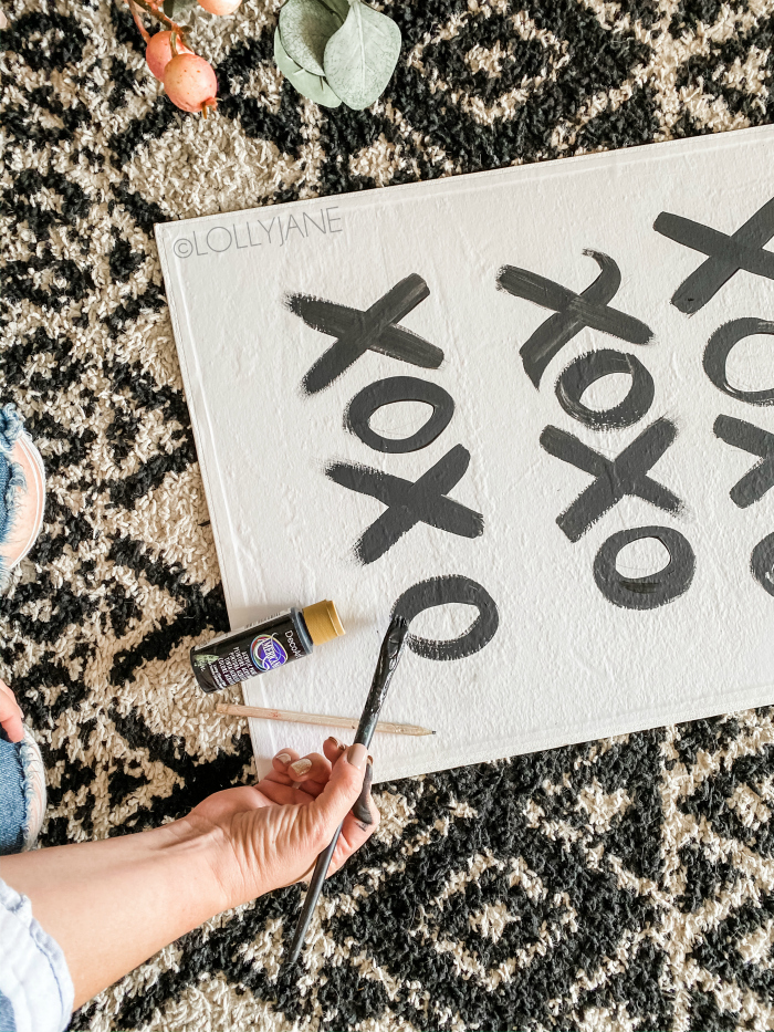 Such an easy Valentines Day hack: hand brush x's and o's onto a canvas for a quick Valentines Day art. #xoxo #valentinesdayart #easyvdayart #valentinesdaymantel #diycanvas #paintedcanvasideas