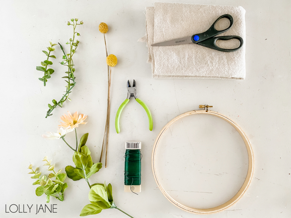 Gather supplies to make a simple Canvas Banner Hoop Wreath to dress up your front door! Such a fun and affordable home decor craft to make! #handmadewreath #diywreath #canvasbanner #diyhomedecor #homedecor #easytomakewreath