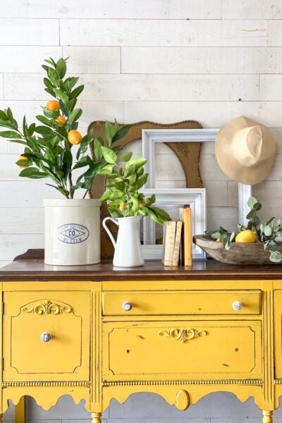 Welcome summer with these EASY entryway decor tips! #entryway #mantel #summerdecor #summertime #summerhomedecor #lemons #lemondecor #lemonhomedecor #yellowbuffet