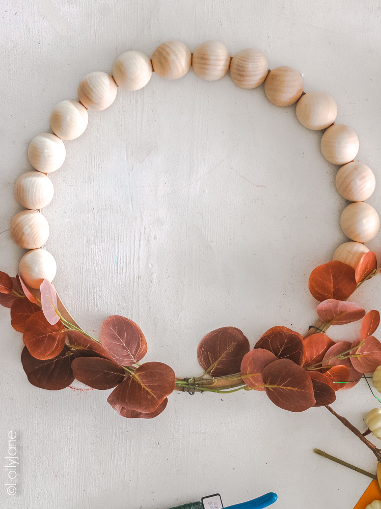 Love the natural faux elements paired with those gorgeous split wood beads in this easy-to-make wreath! #woodbead #woodbeads #splitwoodbead #splitbead #beadwreath #diywreath #wreaths #fallwreath #handmade