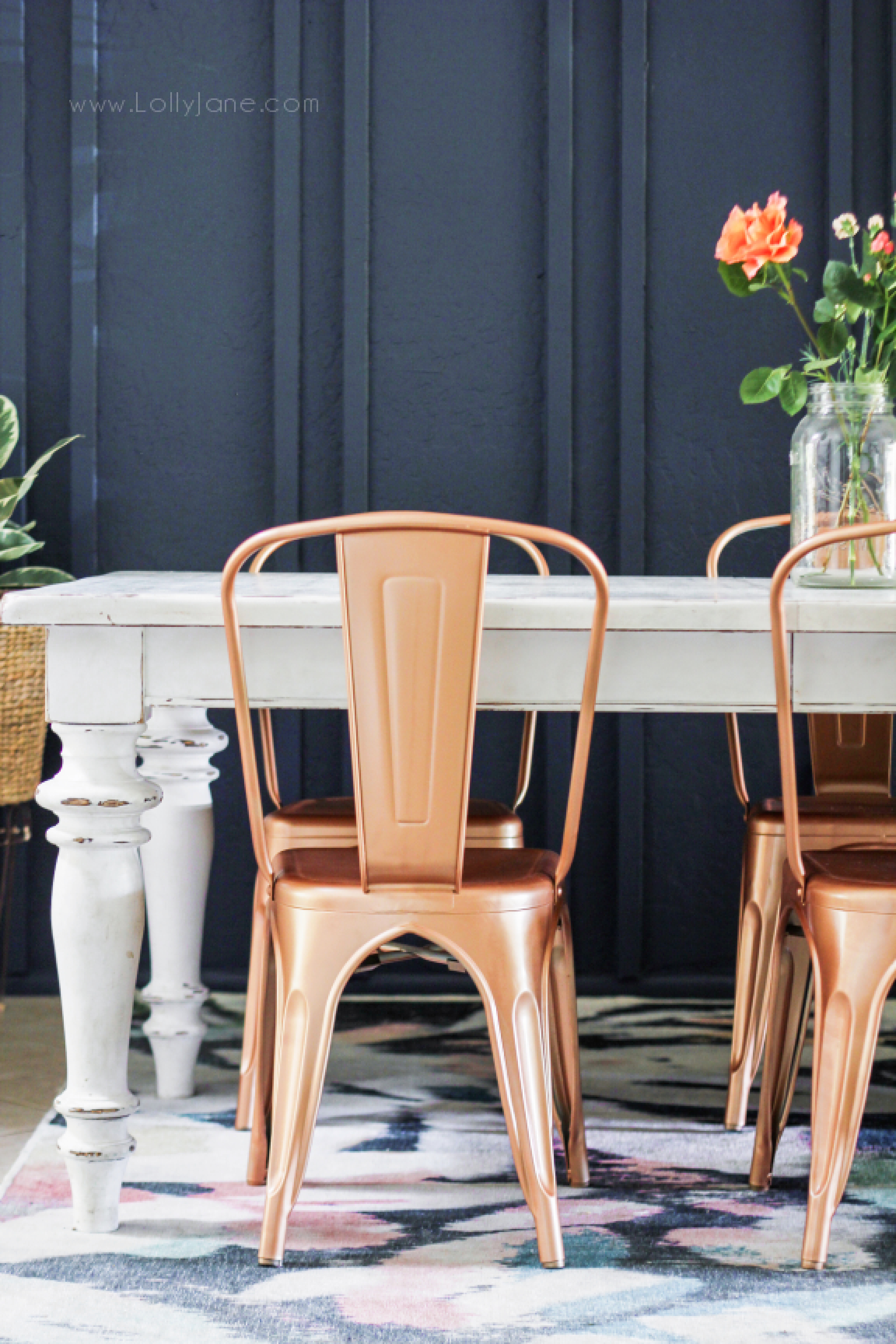 This dining room makeover is a total transformation, wow! With less than $300, we built a double batten wall treatment, primed and painted it, painted the dining room chairs and added a thrifted basket wall! Come check out all the details of this darling navy boho style dining room! #bohodecor #navybluediningroom #navywallideas #copperchairs #spraypaintedbohochairs #rosegoldchairs #howtodecorateadiningroom