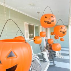 Level up dollar pumpkins for easy Halloween decoration. BONUS: They light up! #dollarpumpkindecor #plasticpumpkinshalloweendecor #hangingpumpkinsporchdecor #hangingpumpkinsoutdoordecor #halloweenoutdoordecor #halloweenporchdecor #halloweenporchpumpkindecor #howtohanghalloweendecor #diyhangingpumpkins