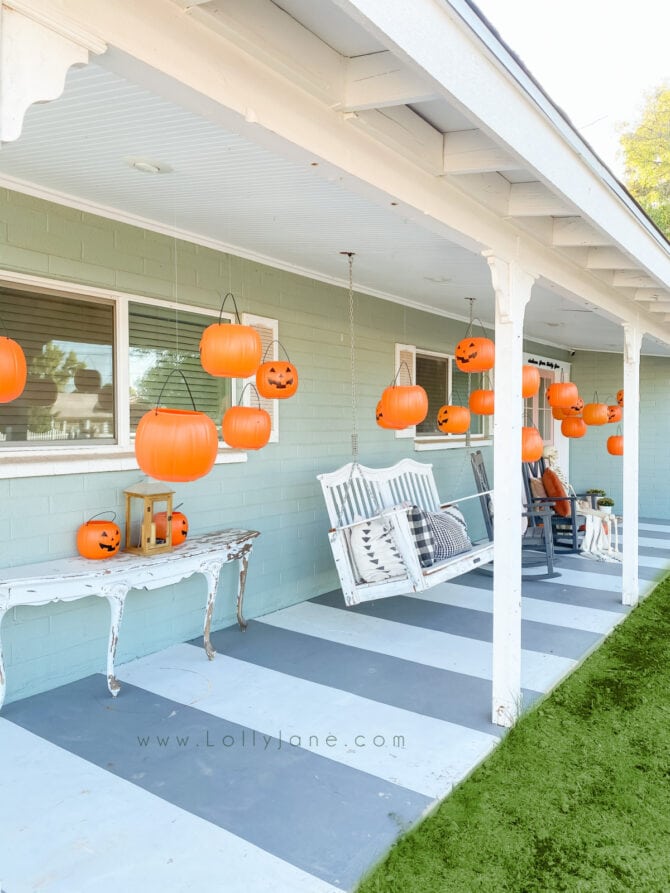 Check out this easy Halloween outdoor setup: use dollar store candy buckets as hanging pumpkins for cute Halloween porch decor! #hangingpumpkins #hangingpumpkinsporchdecor #floatingpumpkinsdecor #floatingpumpkinshalloweendecor #cheaphalloweendecor #halloweendiy #diyhalloweendecor