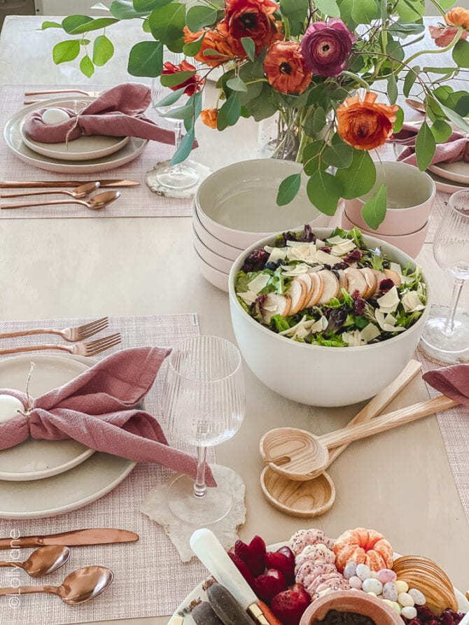 Pretty table scape that's perfect for Easter or spring with pops of pink, florals and gold flatwear! Copy this look, SO easy to copy! #easter #easterdecor #easterdecorations #eastertablecape #springtablescape #tablescape #tabledecor #eastertabledecor