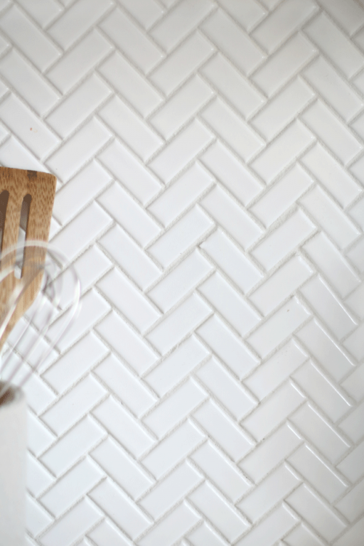 Enjoy a minimal look in the kitchen with white backsplash tiles. When installing a herringbone pattern, the overall look is simple and timeless. We love how our herringbone kitchen backsplash turned out.