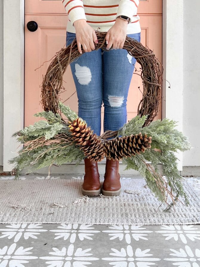 An easy pinecone grapevine wreath using a few picks of greenery, large pinecones and wood branches. Love this easy winter wreath!