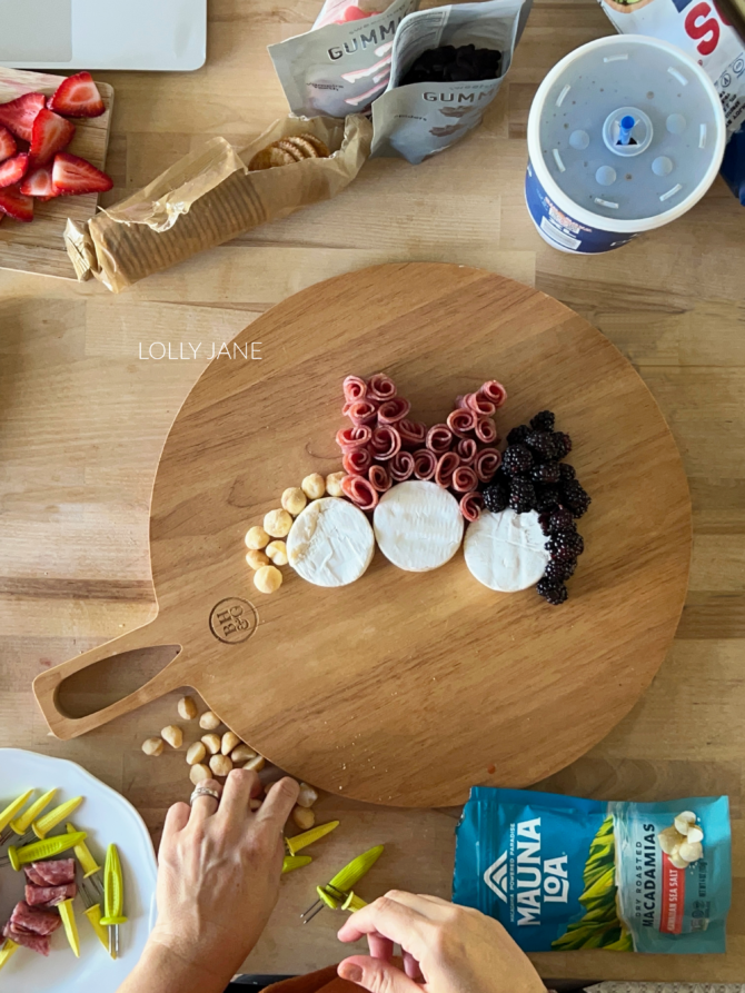How to assemble a Hocus Pocus charcuterie board for a Halloween party or Hocus Pocus movie night! Layers cheese, fruit hair, fruit bodies, chips and candy for an easy Halloween charcuterie board idea!