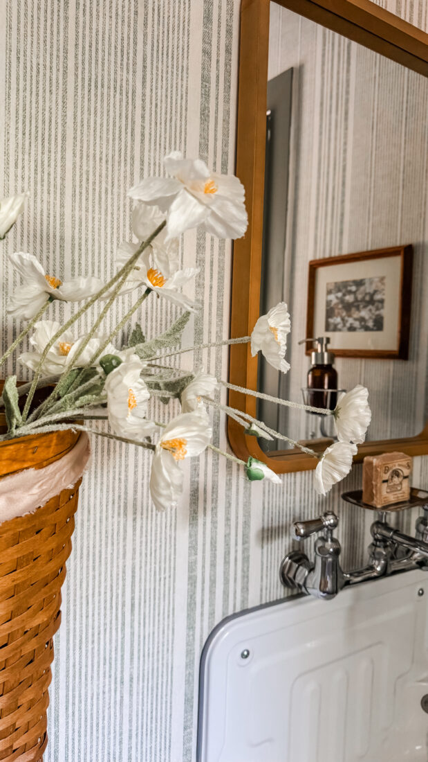 Easy powder room makeover with green trim and basket wall decor.