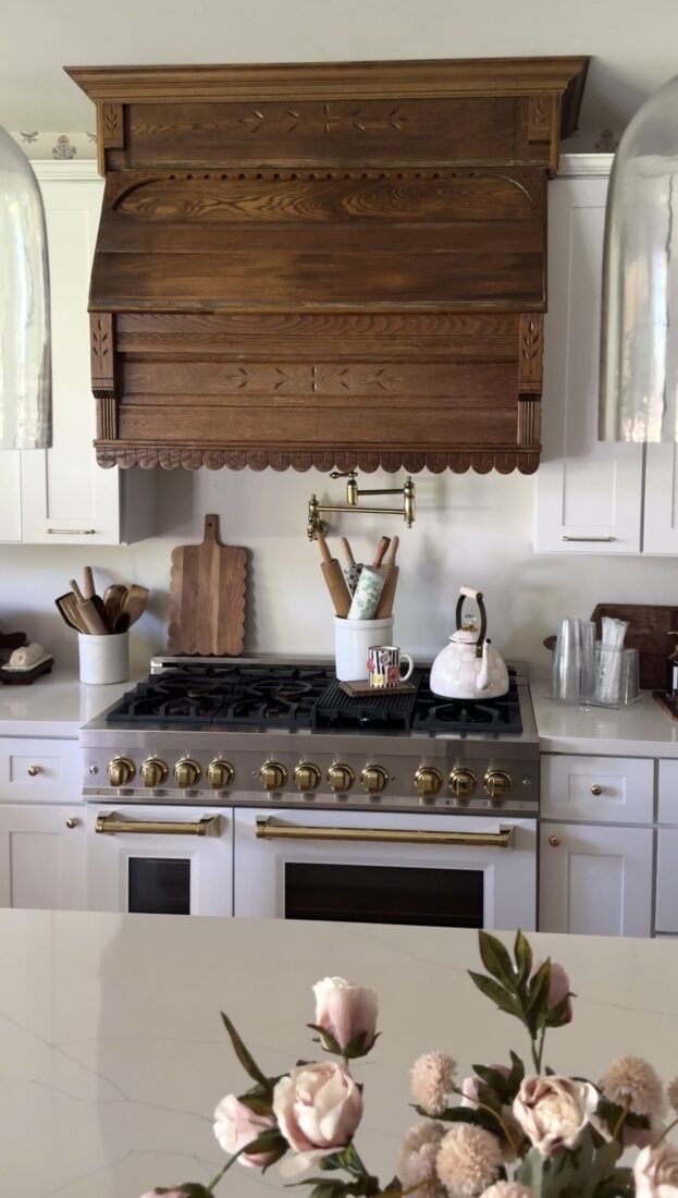 Antique wood kitchen hood beneath vaulted cottage-style ceiling